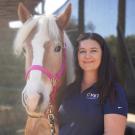 Ali Harman holding a blonde horse